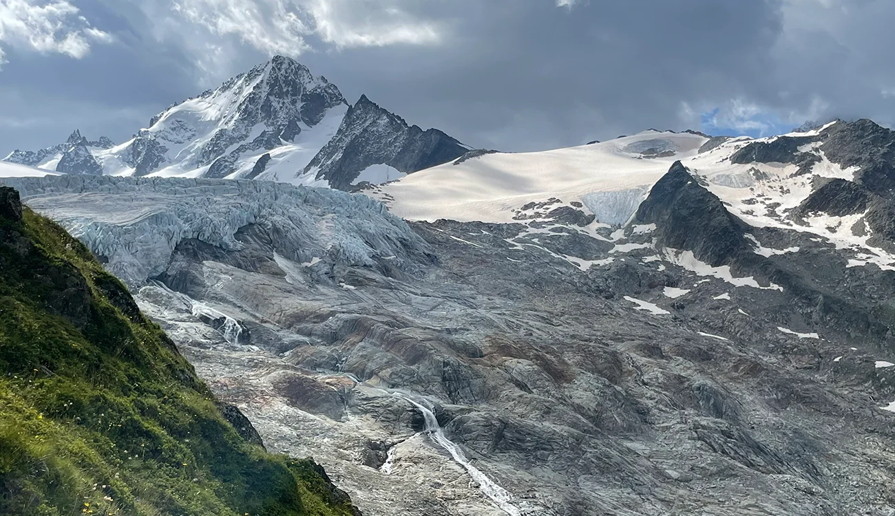 Sweeping panoramic view of Alpine summits seen from a high-altitude viewpoint on a heli-hiking safari in Switzerland or Italy