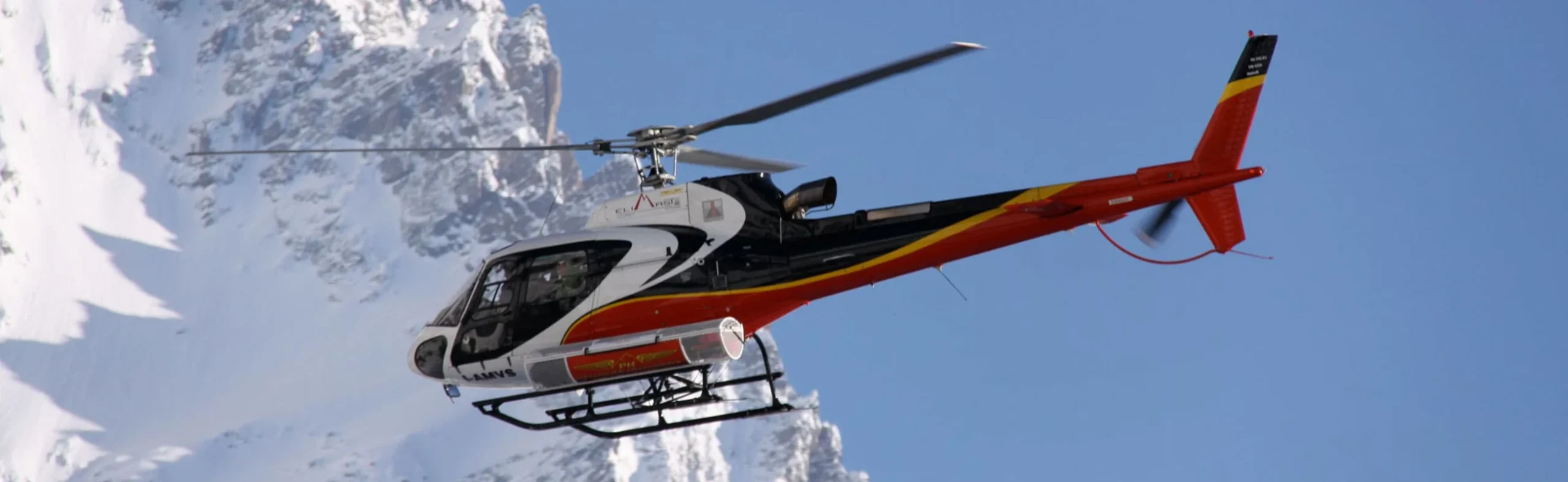 Helicopter flying above a mountain summit