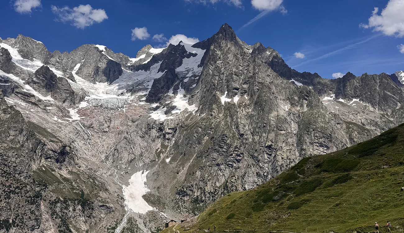 Lush green alpine valley with snow-capped mountain peaks