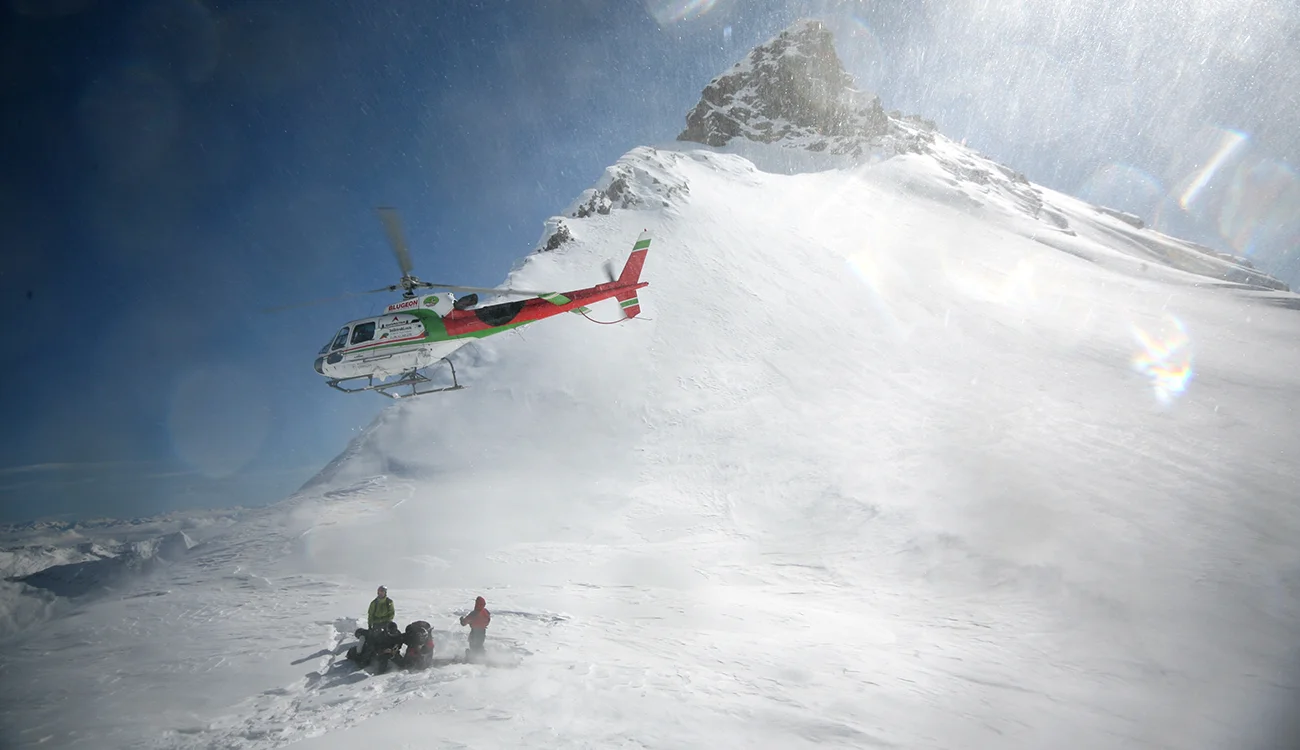 Heli-Ski Safari - Helicopter Drop - Alps Helicopter taking off after dropping off skiers on a heli-ski safari in the Alps
