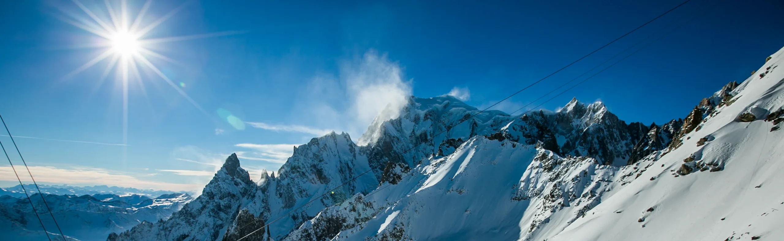 Winter Ski Safari - Mont Blanc Massif - Italy-France Border Panoramic view of the Mont Blanc Massif at 10,000 feet on the Italy-France border, snow-capped peaks and cable car during winter ski safari