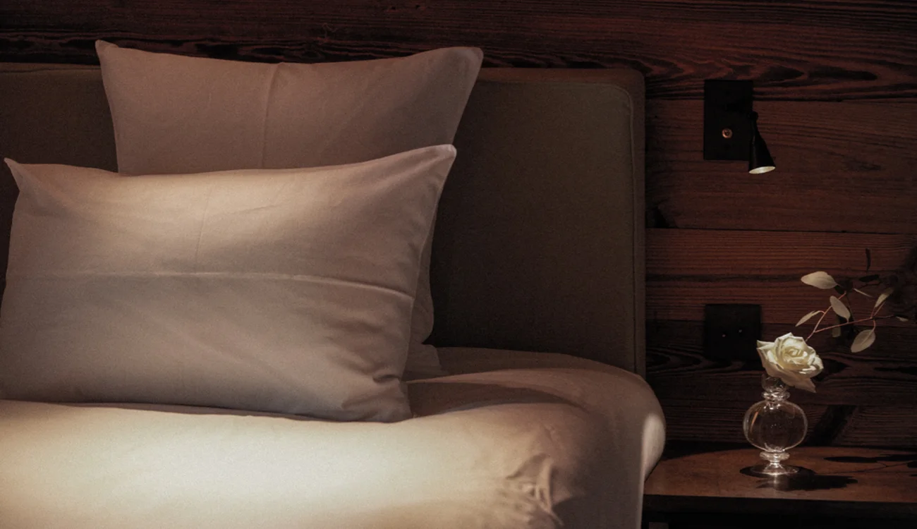 corporate-retreat-luxury-hotel-suite-alps A softly lit luxury hotel suite prepared for a private leadership retreat in the Alps
