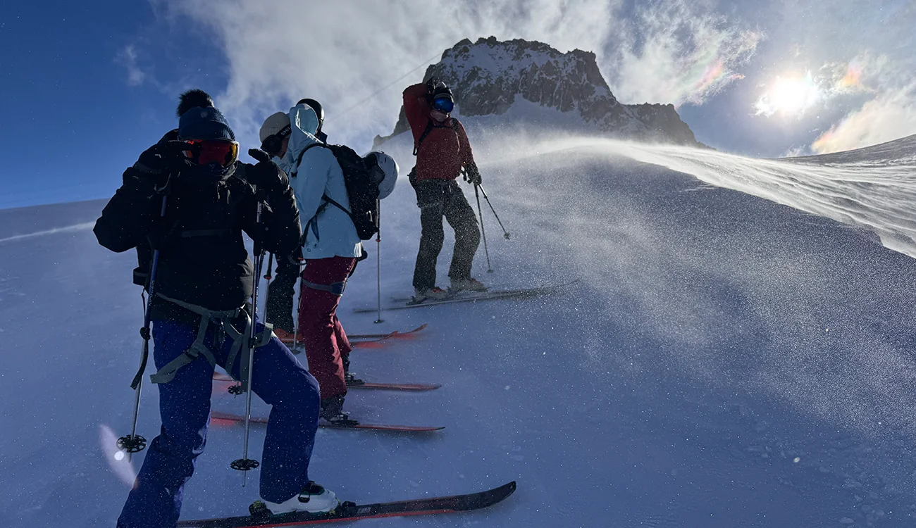 group-of-skiers-on-a-glacier-alps Group of skiers descending a glacier in the Alps during a guided ski safari
